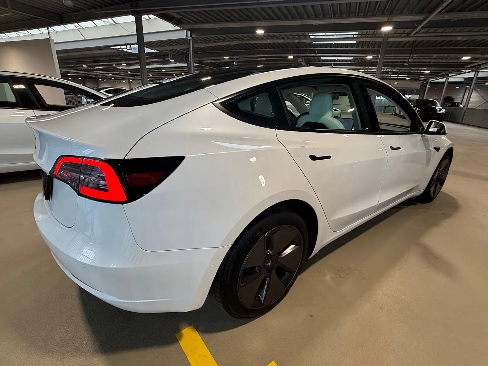 Weißes Tesla Model 3 der Fahrschule Avo